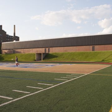 L’aréna est adjacent à la piste d’athlétisme, à laquelle il donne accès. Photographie.